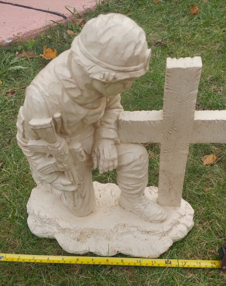 soldier kneeling at cross statue